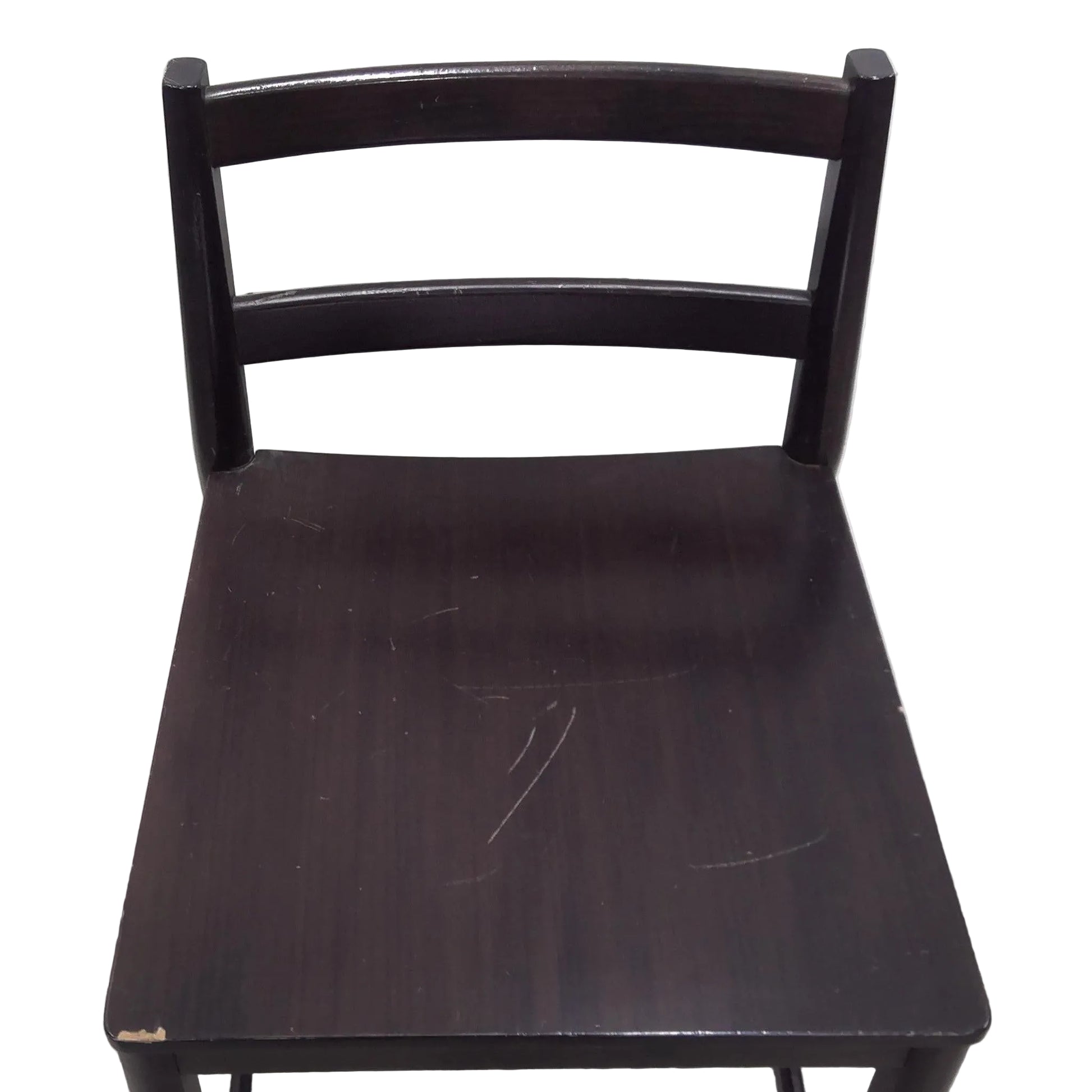 Dark wooden chair with a worn surface against a plain background
