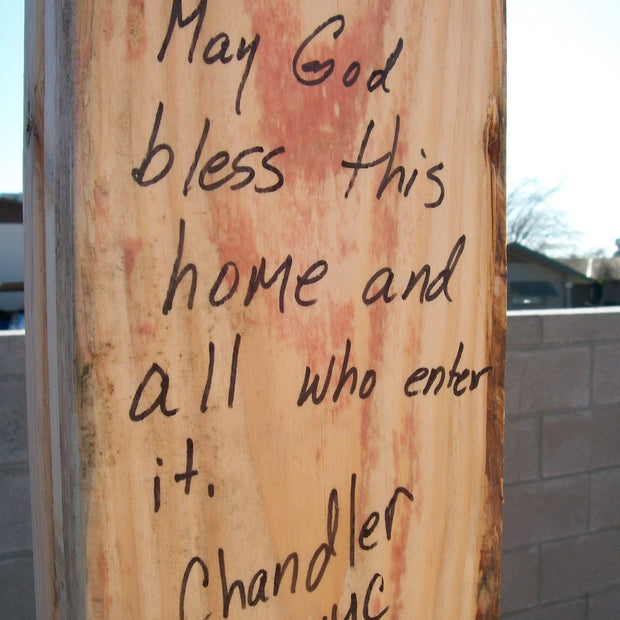 Plywood with message written in marker. 'May God bless this home and all who enter it. Chandler UMC'